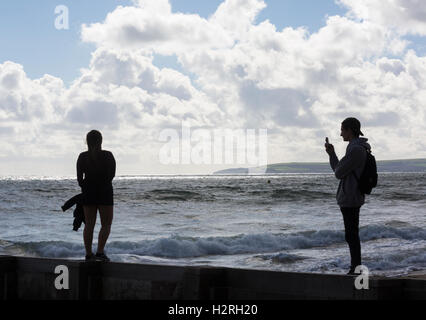 Bournemouth, Dorset, UK 1. Oktober 2016. Menschen nehmen Foto der jungen Frau auf Buhne am Strand von Bournemouth mit durchwachsenem Wetter mit Sonnenschein, Duschen und stürmischen Bedingungen Credit: Carolyn Jenkins/Alamy Live News Stockfoto