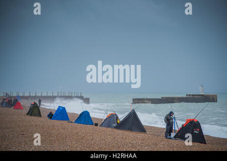 Hastings, Sussex, UK. 1. Oktober 2016. Wellen am Strand Verteidigung als Fischer Unterschlupf in Zelten - Menschen genieße eine Mischung aus Sonnenschein und Duschen an einem windigen Tag am Strand von Hatings. 1. Oktober 2016 Kredit: Guy Bell/Alamy Live-Nachrichten Stockfoto