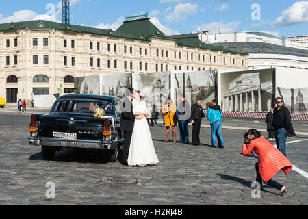 Moskau, Russland. Samstag, 1. Oktober 2016. Warmes und sonniges Wochenende in Moskau, Russland. Die Temperatur ist so hoch wie 18 Grad Celsius (+ 64F). Dies ist der letzte Abschied von der warmen Jahreszeit. Nächste Woche startet Herbst inmitten. Straße und Parks der Stadt sind voll von Menschen. Samstag ist ein Hochzeiten Tag in Moskau. Nicht identifizierte Braut und Bräutigam fotografieren Erinnerung auf Vasilievsky Piste durch den Kreml und den roten Platz in Moskau. Im Allgemeinen neigen die Menschen in diesen Tagen, Geld zu sparen, nicht um sie auf luxuriöse Hochzeitsfeiern zu verbringen. Bildnachweis: Alex Bilder/Alamy Live-Nachrichten Stockfoto