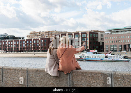 Moskau, Russland. Samstag, 1. Oktober 2016. Warmes und sonniges Wochenende in Moskau, Russland. Die Temperatur ist so hoch wie 18 Grad Celsius (+ 64F). Dies ist der letzte Abschied von der warmen Jahreszeit. Nächste Woche startet Herbst inmitten. Straße und Parks der Stadt sind voll von Menschen. Eine perfekte Aufnahme. Zwei unbekannte schöne Mädchen sitzen auf der Brüstung des Museon Park der Künste und nehmen ein Selbstporträt. Die Moskwa-Fluss im Hintergrund. Bildnachweis: Alex Bilder/Alamy Live-Nachrichten Stockfoto