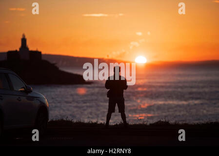 Swansea, Großbritannien. 2. Oktober 2016. UK-Wetter: Ein Mann wacht die Sonne aufgehen über Armband Bay in der Nähe von Mumbles, Swansea heute Morgen auf den Start von einem wunderschönen Herbsttag. Bildnachweis: Phil Rees/Alamy Live-Nachrichten Stockfoto