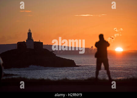 Swansea, Großbritannien. 2. Oktober 2016. UK-Wetter: Ein Mann wacht die Sonne aufgehen über Armband Bay in der Nähe von Mumbles, Swansea heute Morgen auf den Start von einem wunderschönen Herbsttag. Bildnachweis: Phil Rees/Alamy Live-Nachrichten Stockfoto