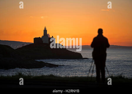 Swansea, Großbritannien. 2. Oktober 2016. UK-Wetter: Ein Mann fotografiert die Sonne aufgehen über Armband Bucht in der Nähe von Mumbles, Swansea heute Morgen auf den Start von einem wunderschönen Herbsttag. Bildnachweis: Phil Rees/Alamy Live-Nachrichten Stockfoto