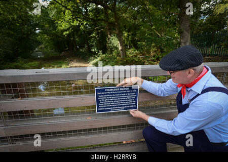 Gekleidet wie ein Kanal Navvy ein Wey & Arun Canal Vertrauen freiwillige behebt eine Gedenktafel an die neue Zirkel-Brücke bei seiner offiziellen Eröffnung auf dem Gipfel auf Alfold, Surrey, England. Die neue Brücke wurde anlässlich des 200. Jahrestages des Kanals im Oktober 2016 eröffnet. Stockfoto