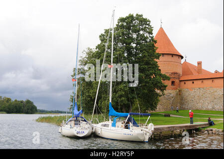 Blick auf die Burg Trakai (in der Nähe von Vilnius), See und zwei Boote mit zwei Personen. Lituania. Stockfoto