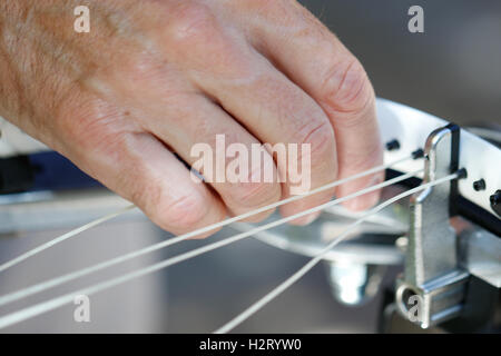 Ein älterer weißer Mann Bespannung Tennisschläger Stockfoto