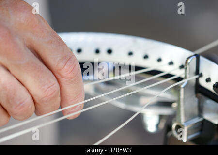 Ein älterer weißer Mann Bespannung Tennisschläger Stockfoto