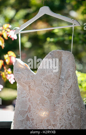 Hochzeitskleid draußen auf einem Kleiderbügel hängen Stockfoto