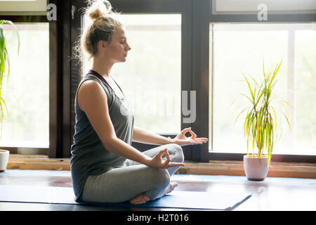 Yoga zu Hause: sinnende Frau Stockfoto