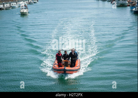 Eine Gruppe von Tauchern in einem Boot auf dem Fluss Arun im Hafen in Littlehampton, West Sussex, England zu reisen. Stockfoto