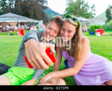 Junger Mann und junge Frau lächelnd, wobei Foto mit Handy, Selfie, Bayern, Deutschland Stockfoto