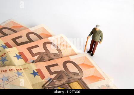 Älterer Mann, Figur und Euro-Noten Stockfoto