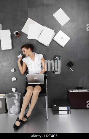 Business-Frau auf dem Boden, irritierende Perspektive Stockfoto