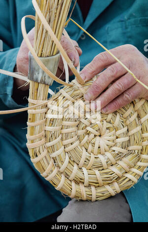 Mann / Imker machen eine traditionelle Bee Skep an bei Dalyseford Herbstshow. England Stockfoto