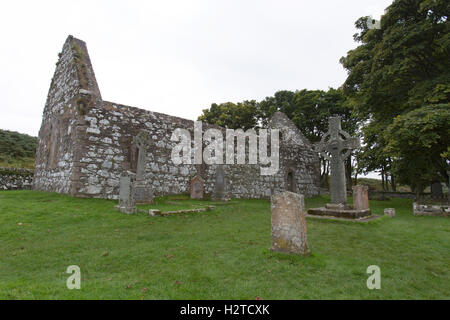 Isle of Islay, Schottland. Malerische Aussicht auf das Kildalton hohe Kreuz und ehemalige Pfarrkirche Kirche von Kildalton. Stockfoto