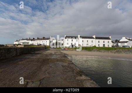 Isle of Islay, Schottland. Auf dem Land entlang Ufer Straße in Port Charlotte, mit dem Strand und dem Pier im Vordergrund. Stockfoto