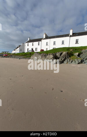 Isle of Islay, Schottland. Malerische Aussicht auf Hütten entlang der Ufer-Straße in Port Charlotte, mit dem Strand im Vordergrund. Stockfoto