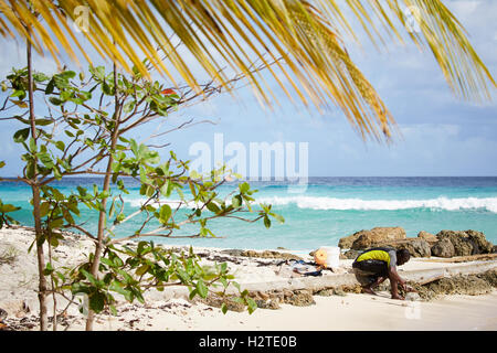 Barbados Hastings Bay Fischer schwarzen männlichen jungen einheimischen Fischen am Strand Meer Armen heruntergekommenen Müll ungepflegt beraubt comm Stockfoto