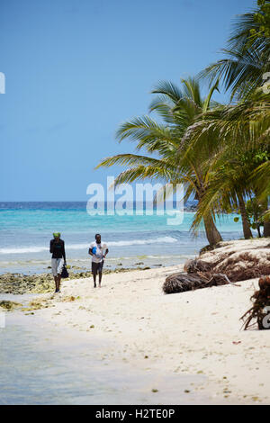 Barbados Hastings Bay Fischer goldenen Sandstrand Palm Bäume Küste zu Fuß Fischer tragen Stangen Exemplar Stockfoto