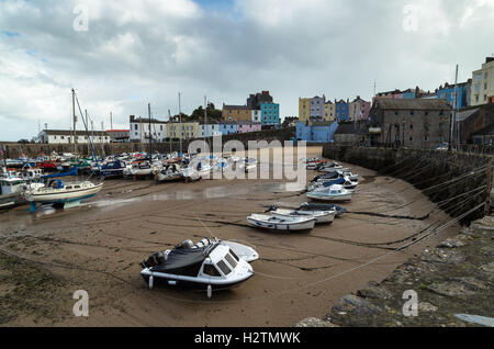 Landschaftsfoto kleine Fischerboote und Jollen warten auf die nächste Flut in Tenby Hafen, Pembrokeshire, Wales Stockfoto