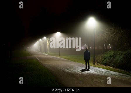 Einzelne Person gehen auf der Straße in der dunklen Nacht Stockfoto