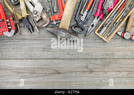 verschiedene alte rostige Werkzeuge und Instrumente für Hand arbeiten und Reparatur auf hölzernen Hintergrund Haus Stockfoto