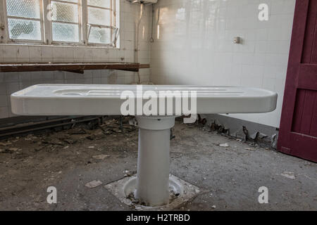 Ein immer seltener Porzellan-Seziertisch in verlassenen Maiden Recht Krankenhaus Leichenhalle, Lanchester, County Durham, Großbritannien Stockfoto