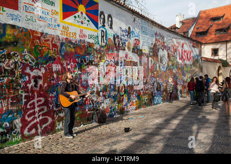 Straßenmusikant an der John-Lennon-Mauer in Prag. Nach seiner Ermordung im Jahr 1980 war es eine politische Graffiti Protest von der junge Tscheche Stockfoto