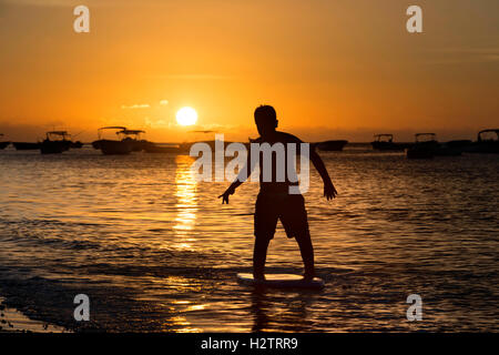 Surfen bei Sonnenuntergang am Strand von Tamarin, Mauritius. Stockfoto