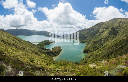 Lagoa Fogo mit dem Ozean hinaus. Blick hinunter auf eine grüne See Fogo aus dem Miradouro da Lagoa Fogo mit vielen cumulus Stockfoto