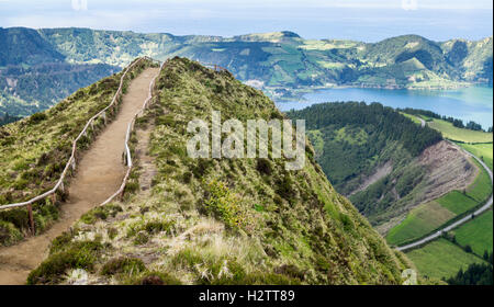 Pfad zum Aussichtspunkt & die Straße unten. Ein Feldweg mit hölzernen Geländer Winde über die Hügel zu einem spektakulären Aussichtspunkt Stockfoto