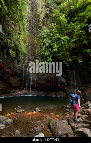 Junge weibliche Wanderer beobachten die 25 Fontes Wasserfälle in den Bergen von Rabaçal, Madeira, Portugal Stockfoto