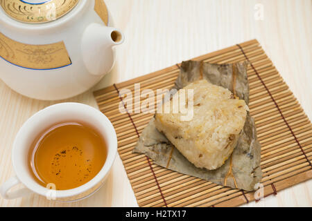 traditionelle chinesische Klebreis Knödel mit Tasse Tee und Teekanne horizontale Komposition Stockfoto