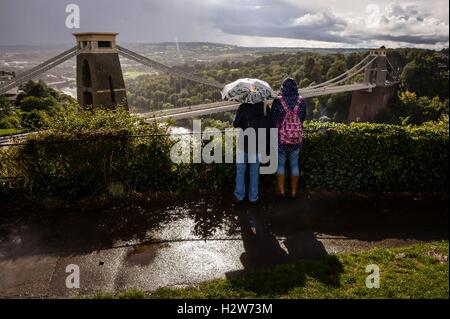 Menschen blicken über die Clifton Suspension Bridge in der Nähe von Bristol bei starkem Regen. Stockfoto