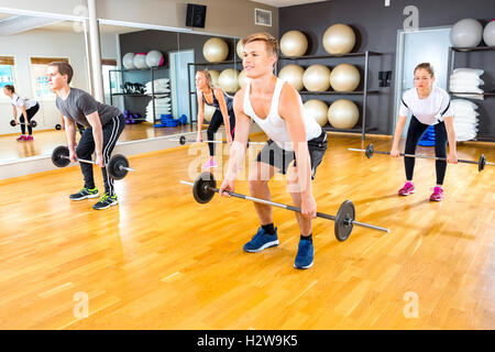 Freunde, die Ausübung Kreuzheben mit Hanteln Gewichte im Fitnessstudio Stockfoto