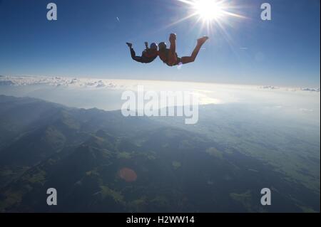 zwei Fallschirmspringer in den Himmel über Gruyères mit dem Genfer See im Hintergrund Stockfoto