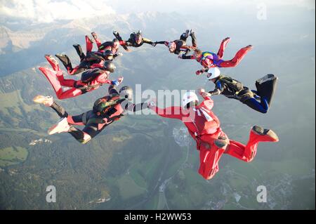 Neun Fallschirmspringer bilden eine Sternentstehung über Gruyères in der Schweiz Stockfoto