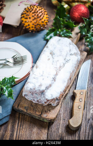 Christstollen Weihnachtsstollen am festlich gedeckten Tisch mit Xmas Ornamente Stockfoto