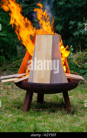 eine brennende Laminat-Paneele in offenes Feuer auf einen Grillplatz Stockfoto