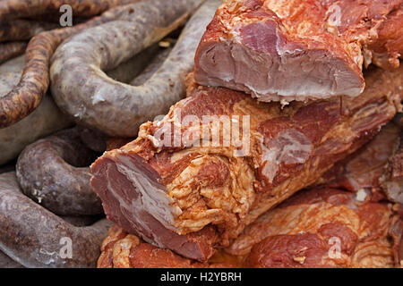 Verschiedene geräucherte Fleischspezialitäten, auf einen Tisch gestellt und zum Verkauf ausgesetzt. Stockfoto