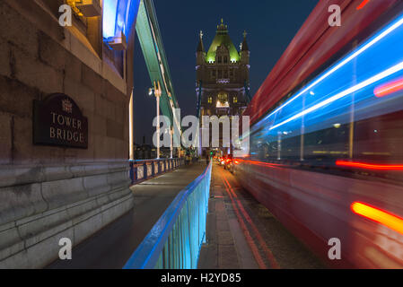 Verschwommen Routemaster Bus und Glanz des Verkehrs auf die Tower Bridge über die Themse bei Nacht, London, UK Stockfoto