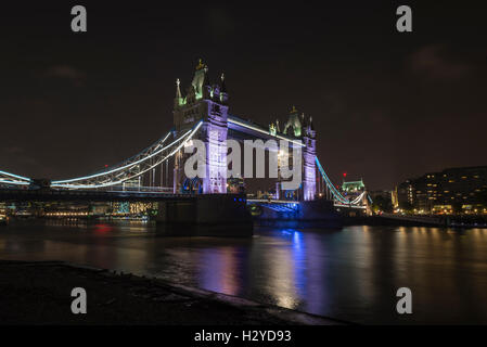 Tower Bridge über die Themse bei Nacht gesehen von Butlers Wharf, London, UK Stockfoto