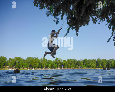 Wien, Wien: junger Mann im Swing über Wasser, Alte Donau (Alte Donau), 22., Wien, Österreich Stockfoto