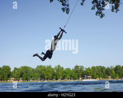 Wien, Wien: junger Mann im Swing über Wasser, Alte Donau (Alte Donau), 22., Wien, Österreich Stockfoto