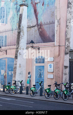 Fahrrad-Verleih-Station unter ein Wandbild einer Tür, Balkon-Baum auf einer Wand in Nancy, Meurthe-et-Moselle, (Grand Est), Frankreich Stockfoto