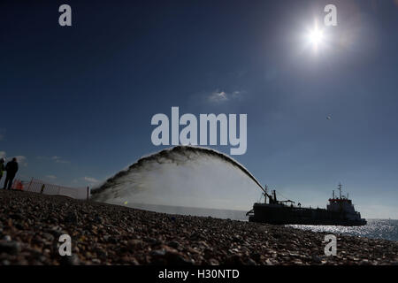 Eine Bagger Pumpen Schindel auf Eastoke Strand von Hayling Island in Hampshire im Rahmen der Küstenverteidigung arbeiten, um das Risiko von Überschwemmungen und Erosion zu reduzieren. Stockfoto