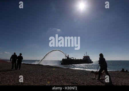 Eine Bagger Pumpen Schindel auf Eastoke Strand von Hayling Island in Hampshire im Rahmen der Küstenverteidigung arbeiten, um das Risiko von Überschwemmungen und Erosion zu reduzieren. Stockfoto