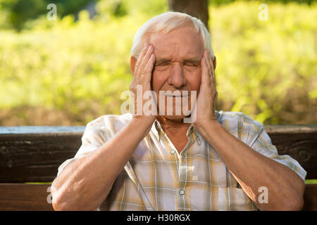 Älterer Mann hat Kopfschmerzen. Stockfoto