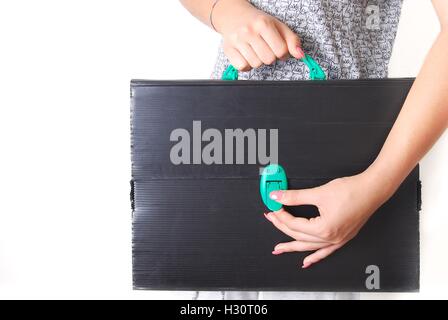 Hände halten eine technische alt und zerstörten schwarze Aktentasche Stockfoto