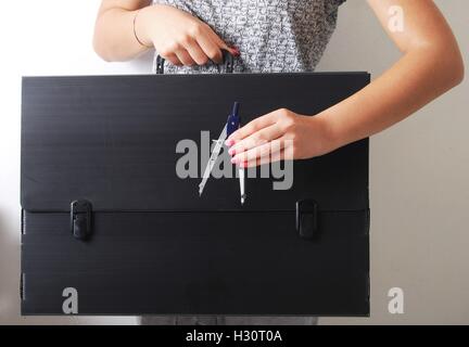 Hände halten einen technischen Kompass auf einer alten und verfallenen schwarz Aktenkoffer Stockfoto
